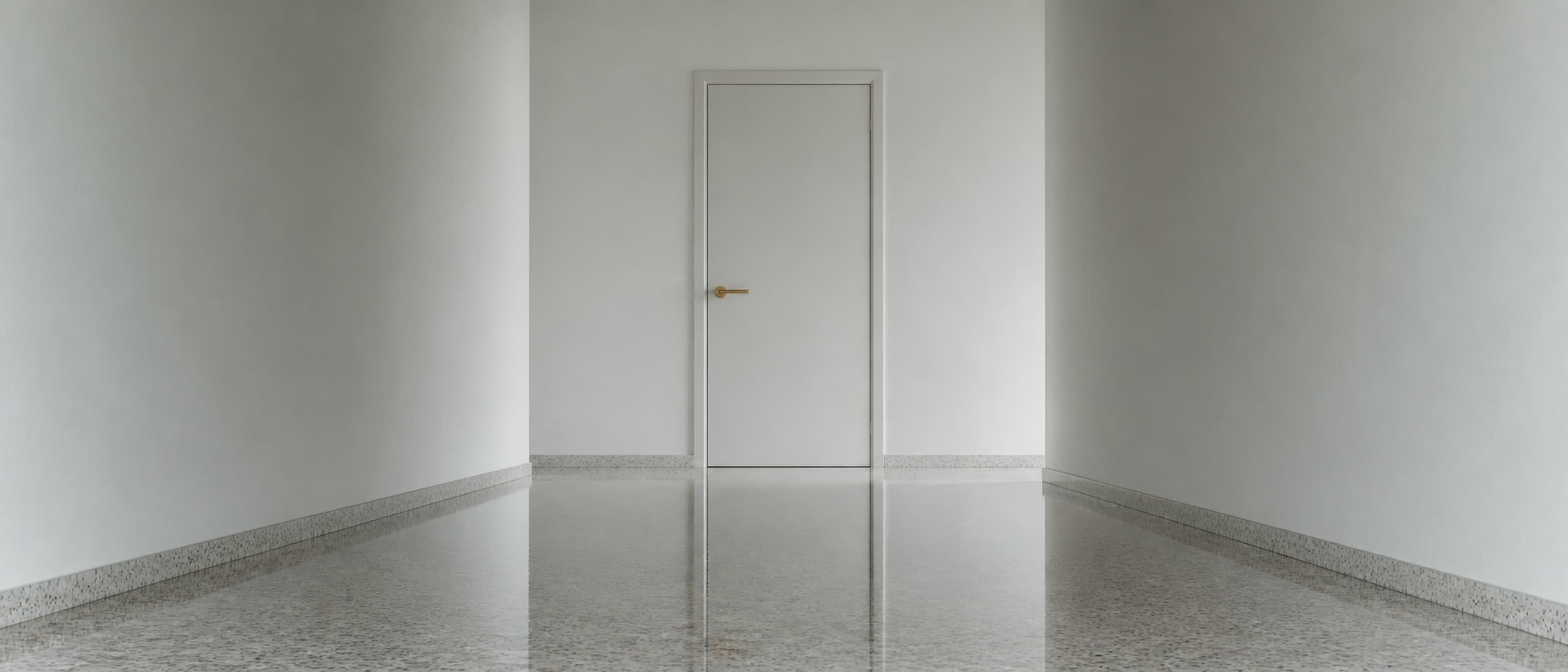 A single closed door in a long, empty corridor